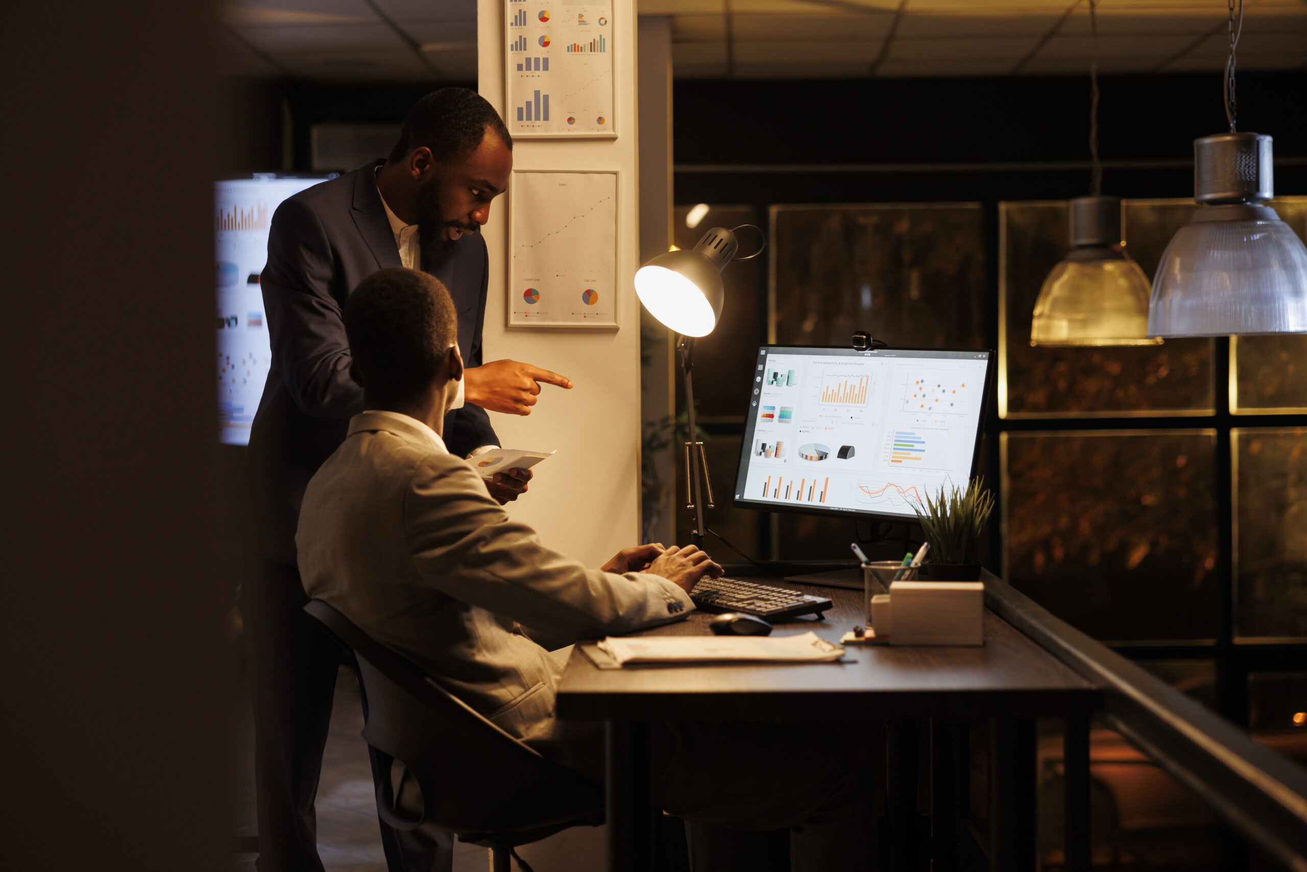Executive managers analyzing financial statistics Executive managers analyzing financial statistics discussing investment strategy while working overhours in startup office. Businessmen planning brainstorming management ideas. Business concept