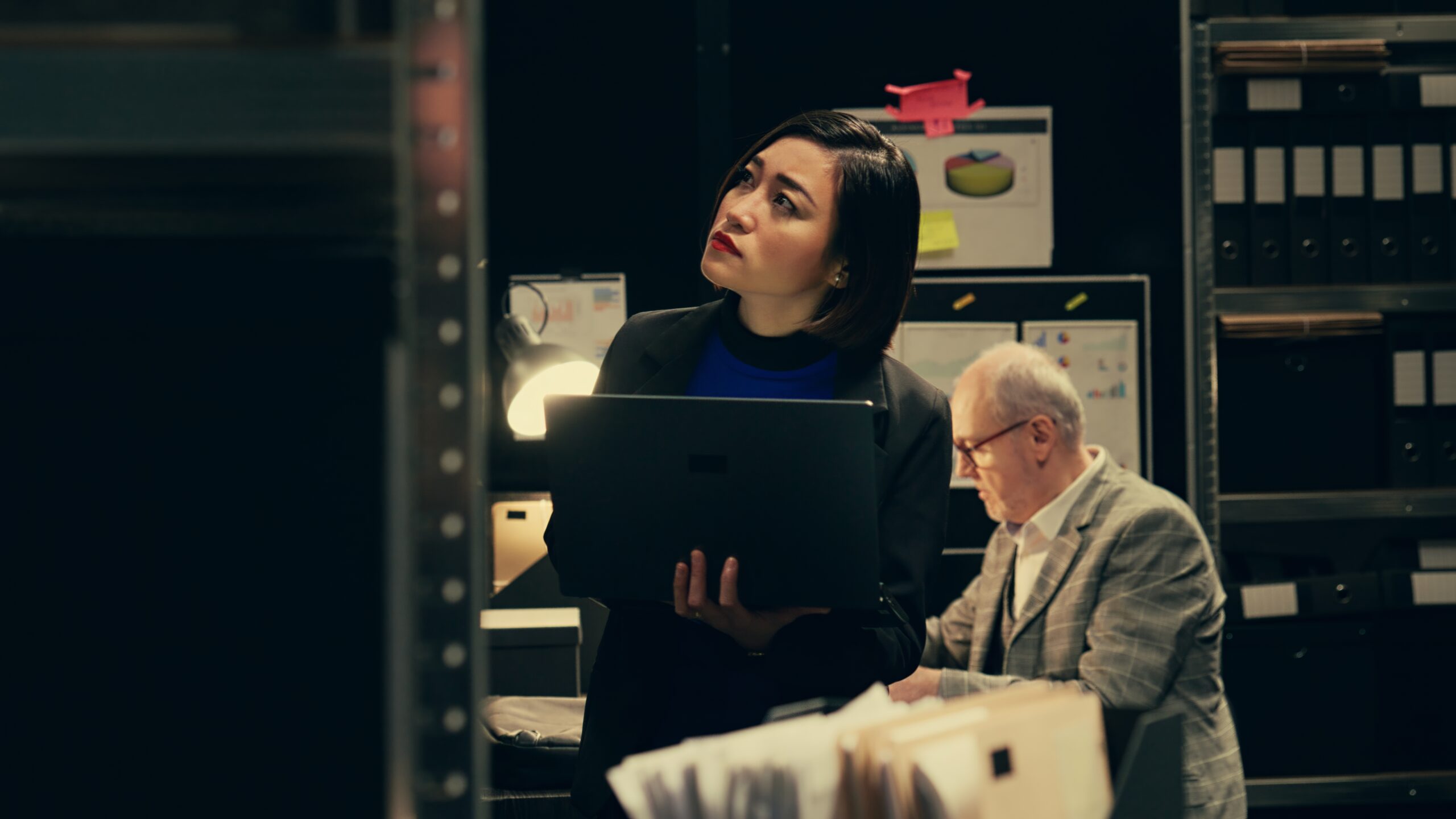 Private investigator organizes archived files for easy access Private investigator organizes archived files for easy access, searching for old file cases to cross reference data. Law enforcement agent looking for classified folders in archive room. Camera B.